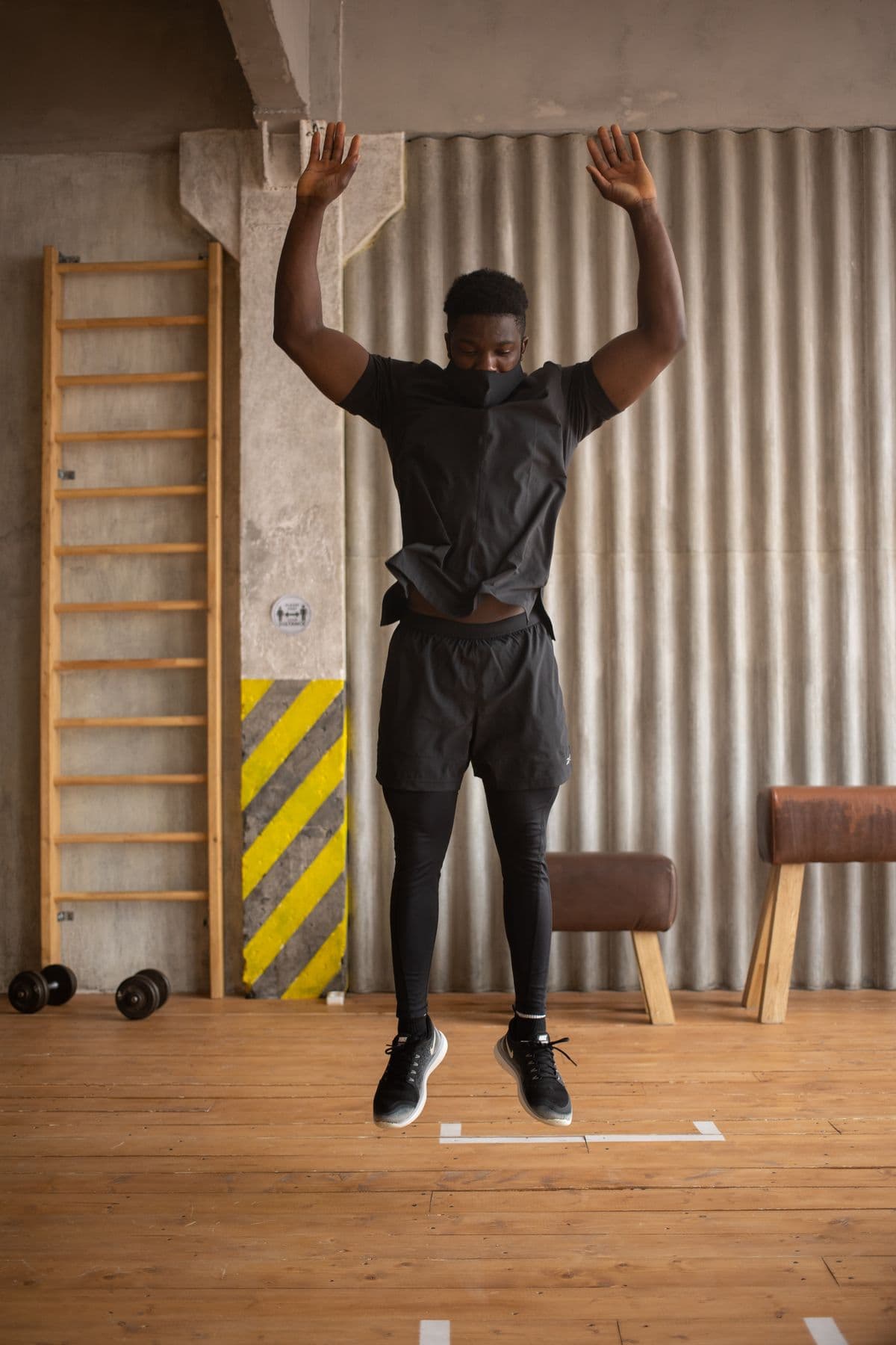 Ein Sportler springt mit erhobenen Armen – die Abschlussbewegung eines Burpees.